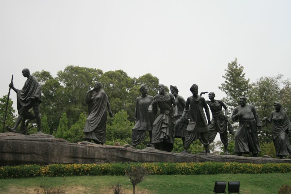Bronze sculptures depicting a famous historical march scene surrounded by greenery.