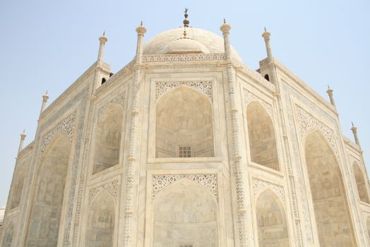 Close-up of the intricately carved marble facade of the Taj Mahal under a clear blue sky., free online jigsaw puzzle on JigsawPuzzlesFreeOnline.org