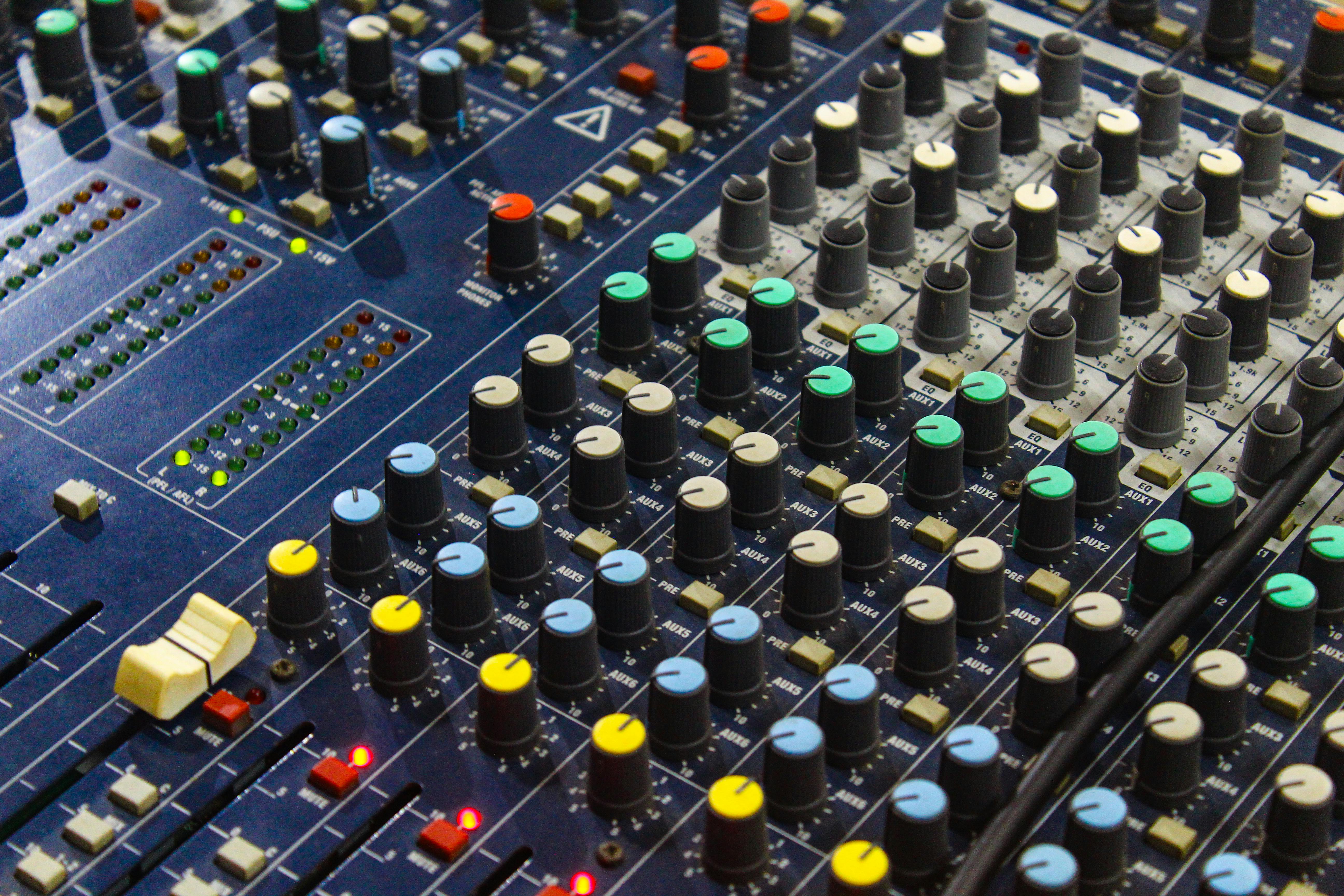 A professional church soundboard with multiple faders and a technician adjusting levels during a service