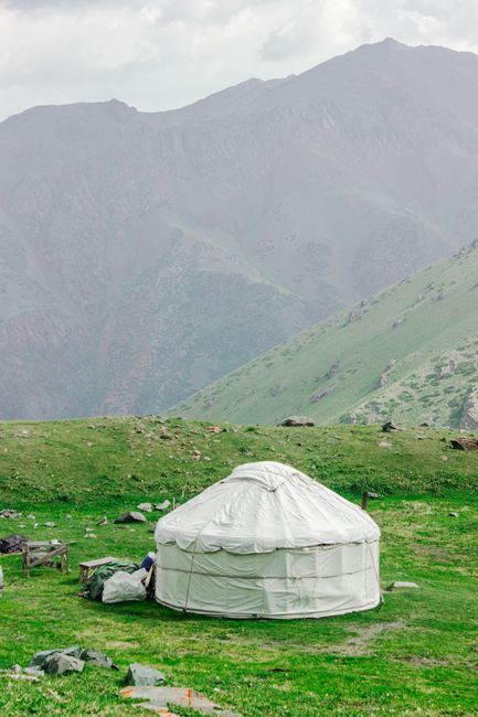 A serene image of a traditional yurt set against the majestic mountains of Kyrgyzstan, showcasing cultural heritage.