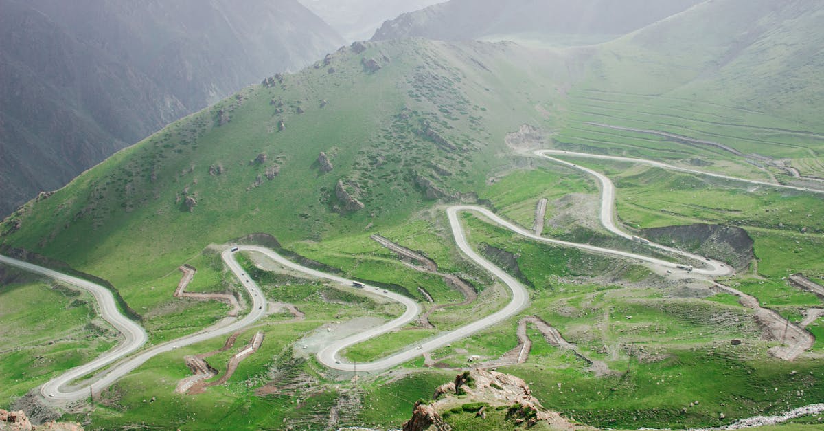 Winding mountain road through lush green hills in the Chüy Region of Kyrgyzstan.