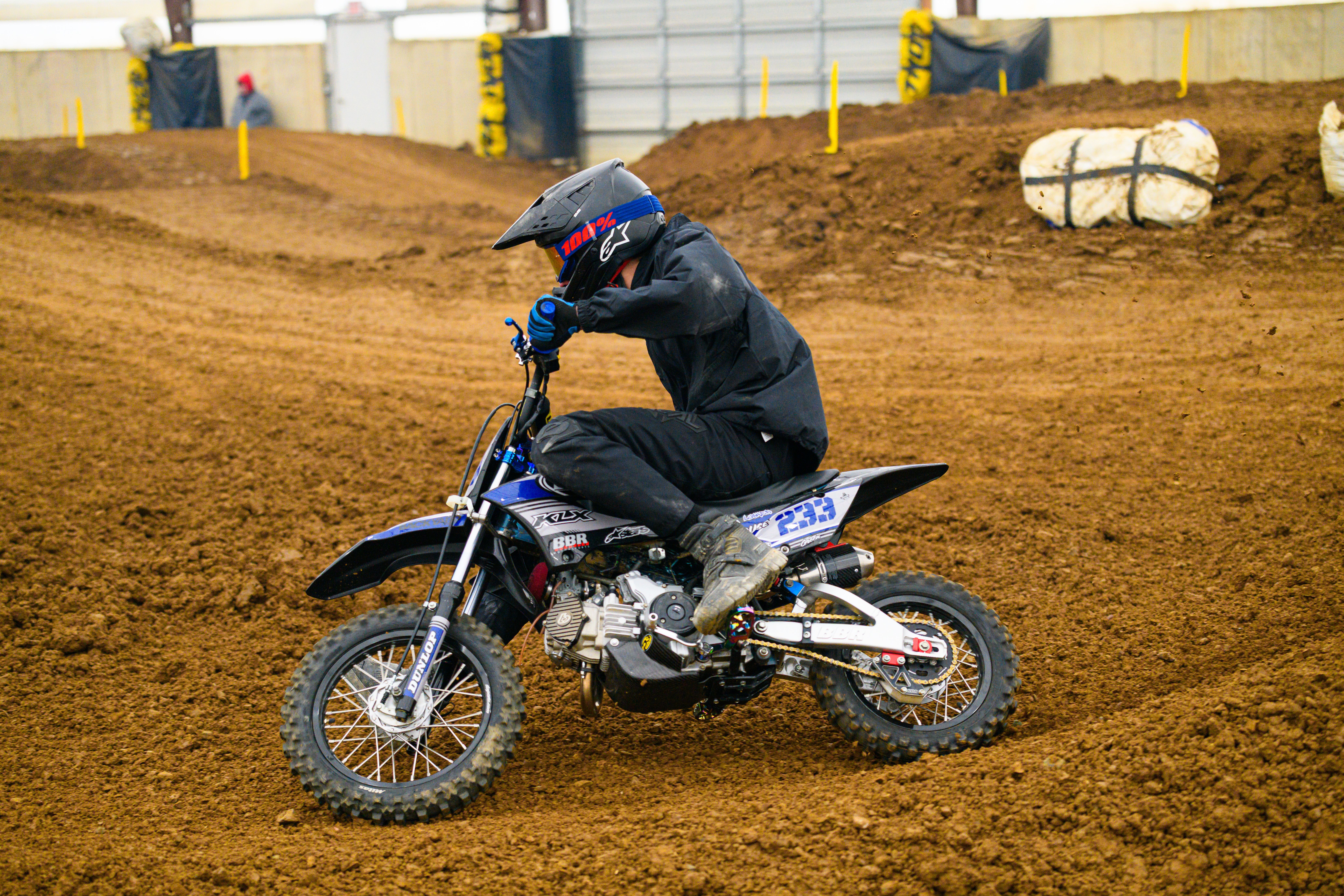 Dynamic action shot of a dirt bike rider competing on an indoor track in Martinsburg, Ohio.