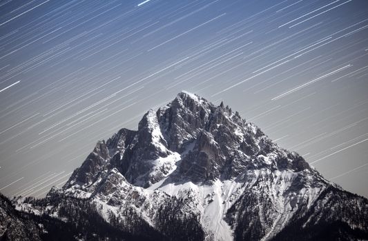 Majestic alpine mountain with starry sky creating stunning night landscape.