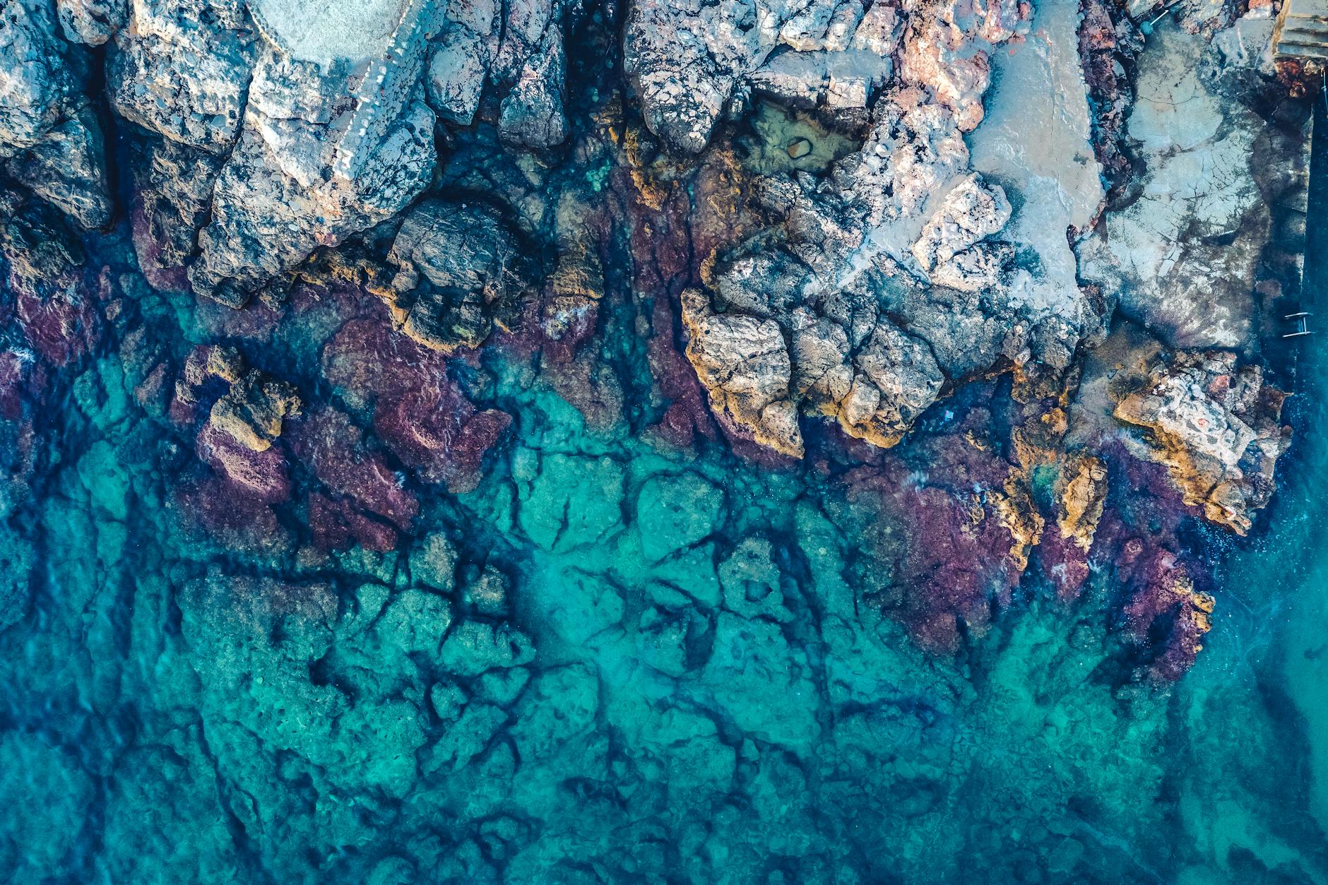 Aerial Photography of Rocks Beside Body of Water