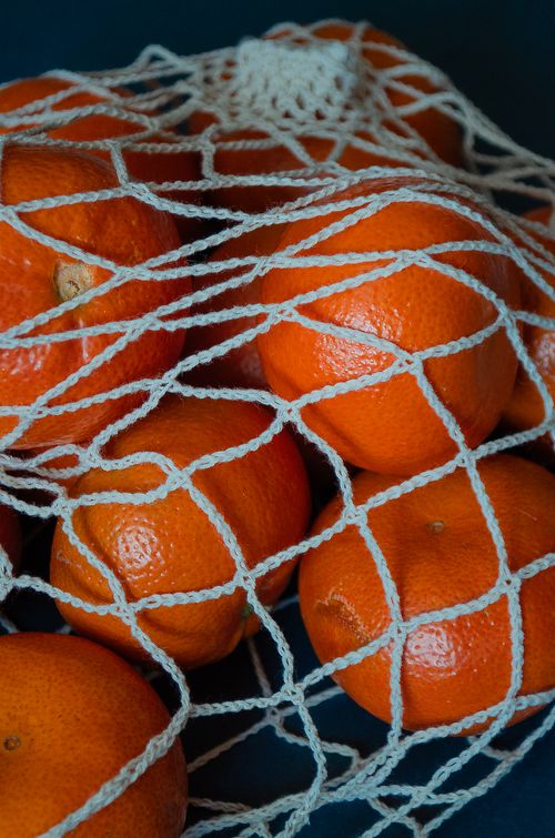 Free Bright oranges inside a reusable string bag showcasing eco-friendly shopping. Stock Photo