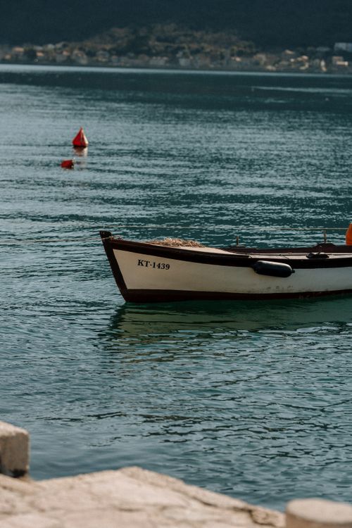 Free A peaceful fishing boat anchored by the shore on a calm, sunny day. Stock Photo