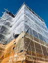 Scaffolded Building Under Construction Against Blue Sky