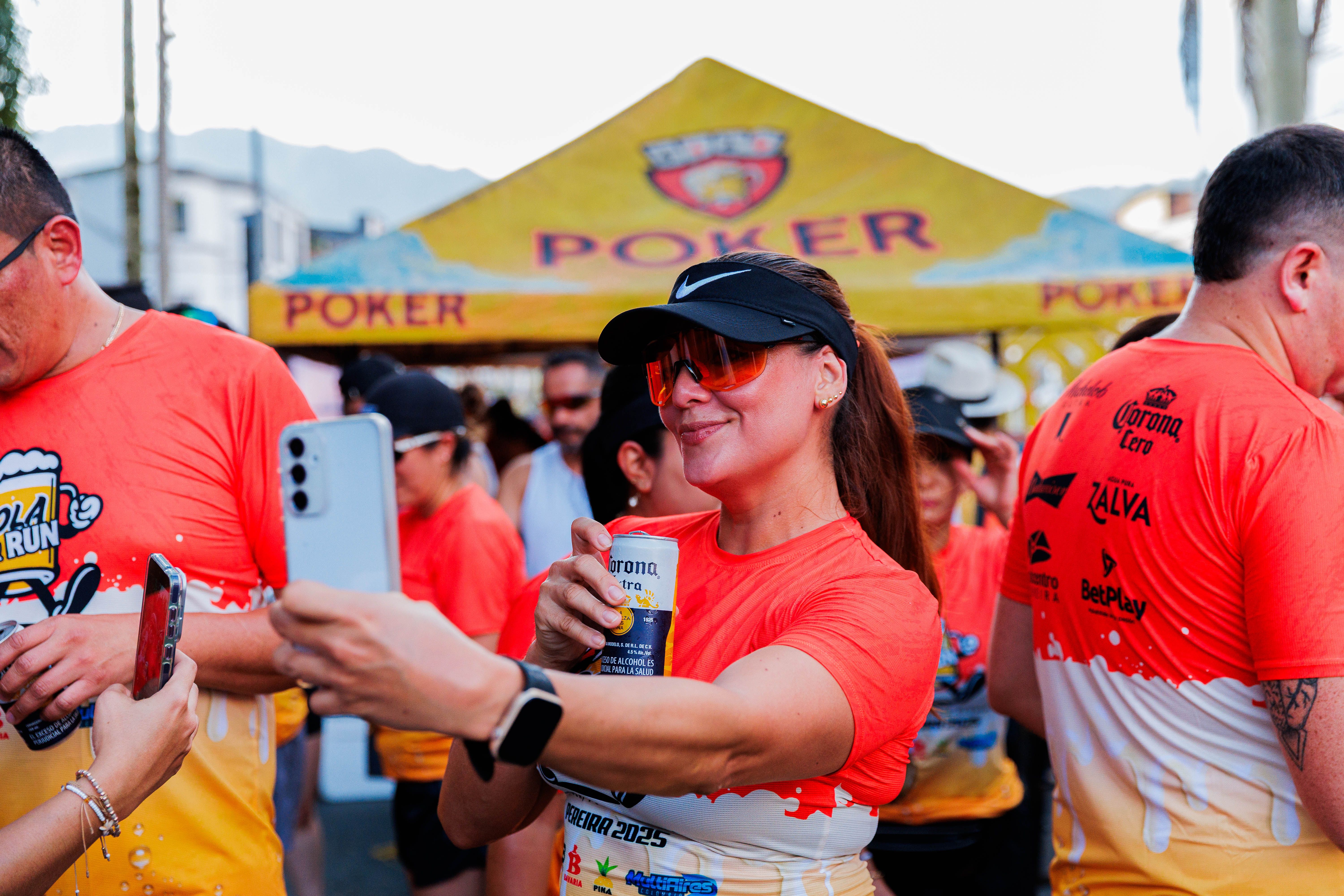 Joyful runners taking selfies and celebrating with drinks after a fun run event.