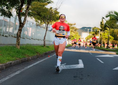 Free Woman running in a vibrant marathon event, showcasing determination and fitness outdoors. Stock Photo