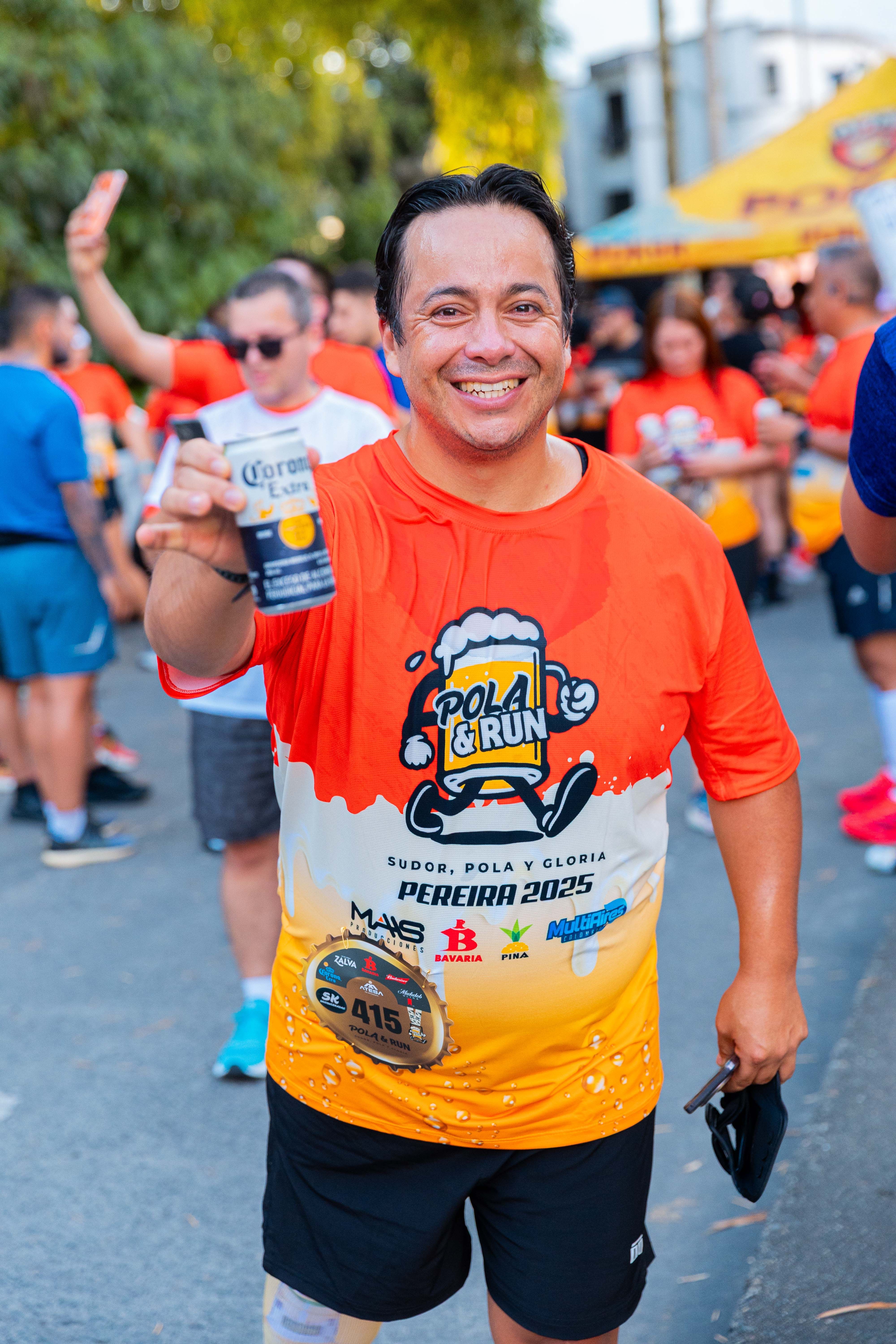 Man celebrating post-race with a drink at an outdoor running event, vibrant atmosphere.