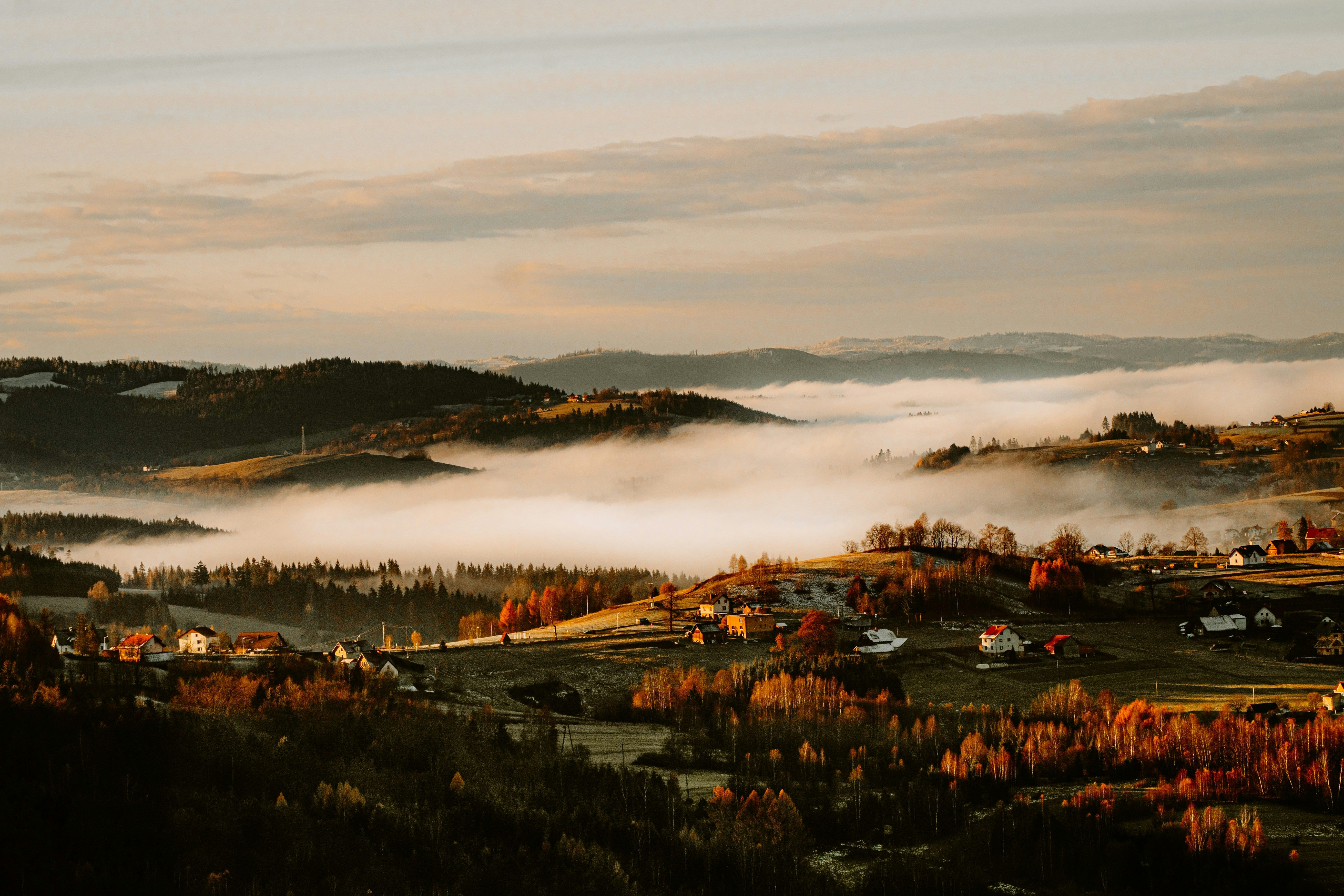 hilltop medieval village at sunrise with mist in the valley, France