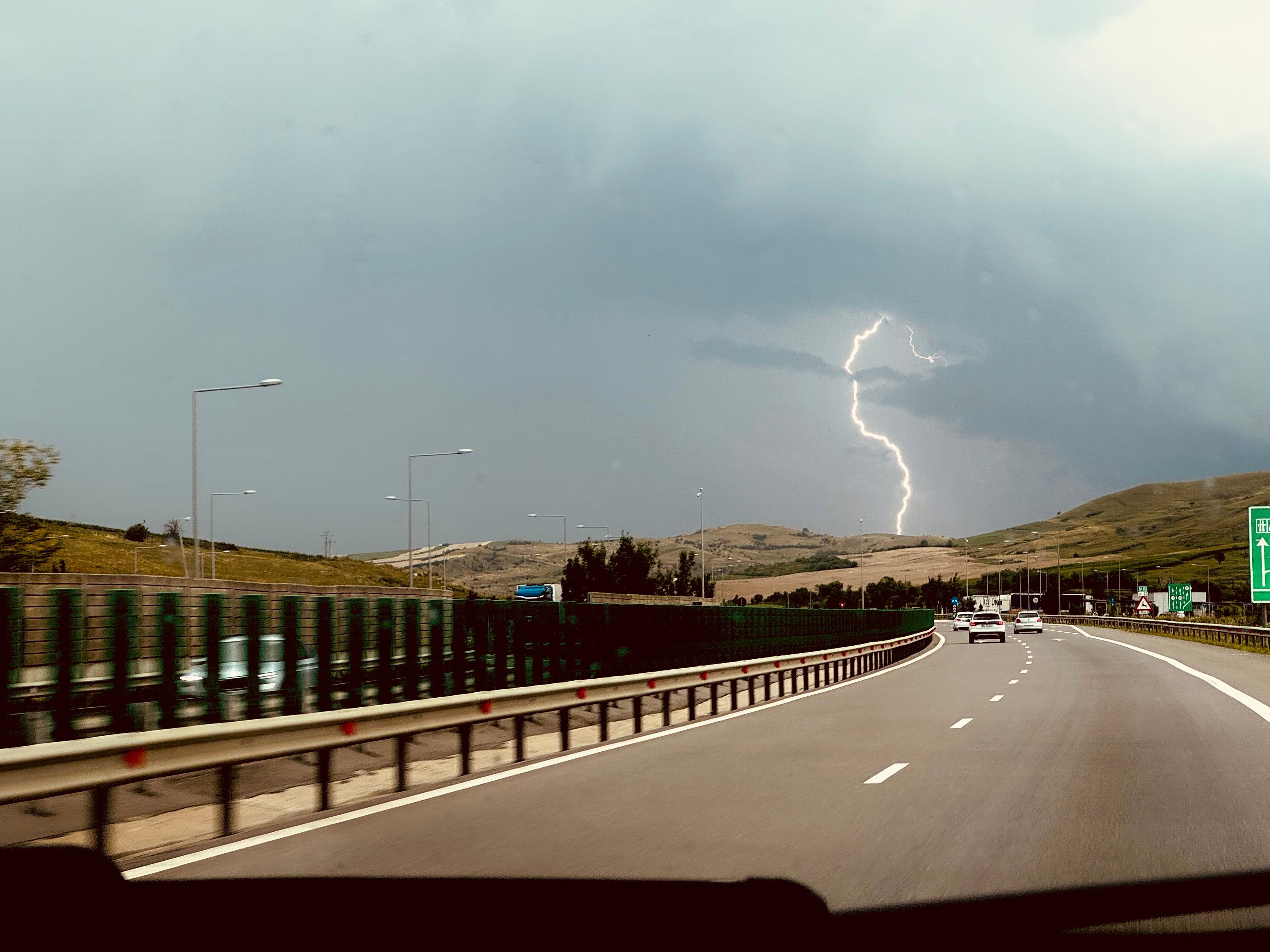 EV on a scenic highway route — planning EV road trip charging stops 2026