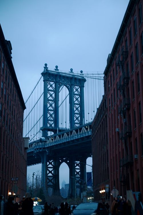 Free View of Manhattan Bridge framed by red brick buildings in DUMBO, Brooklyn, New York City. Stock Photo