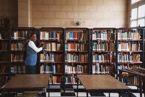 Free A librarian organizes books on shelves in a calm and quiet library setting. Stock Photo