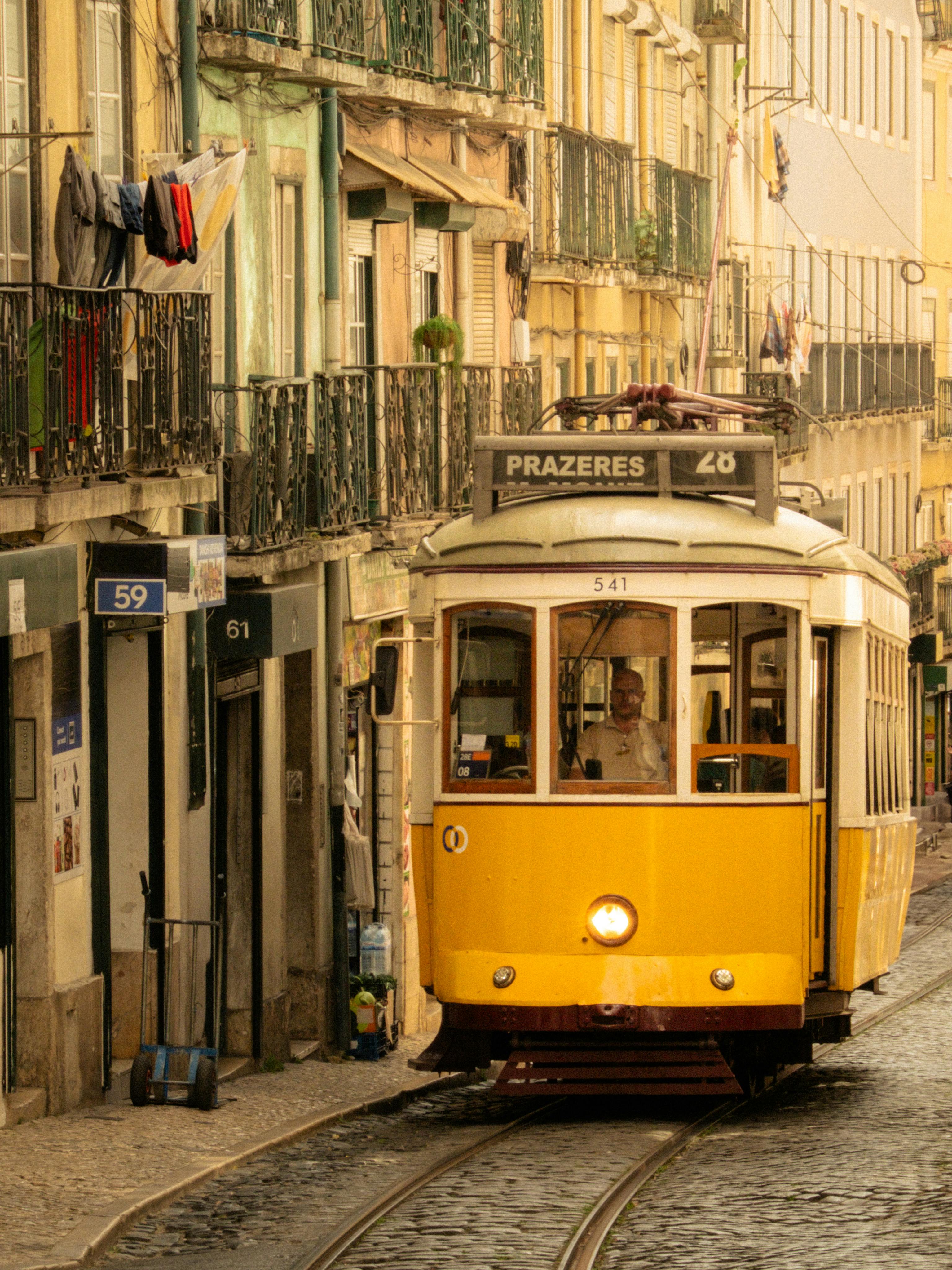 Iconic yellow tram travels through the historic streets of Lisbon, Portugal.