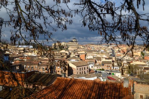 Free Aerial view of Toledo, Spain, showcasing historic rooftops and distant landmarks under dramatic skies. Stock Photo