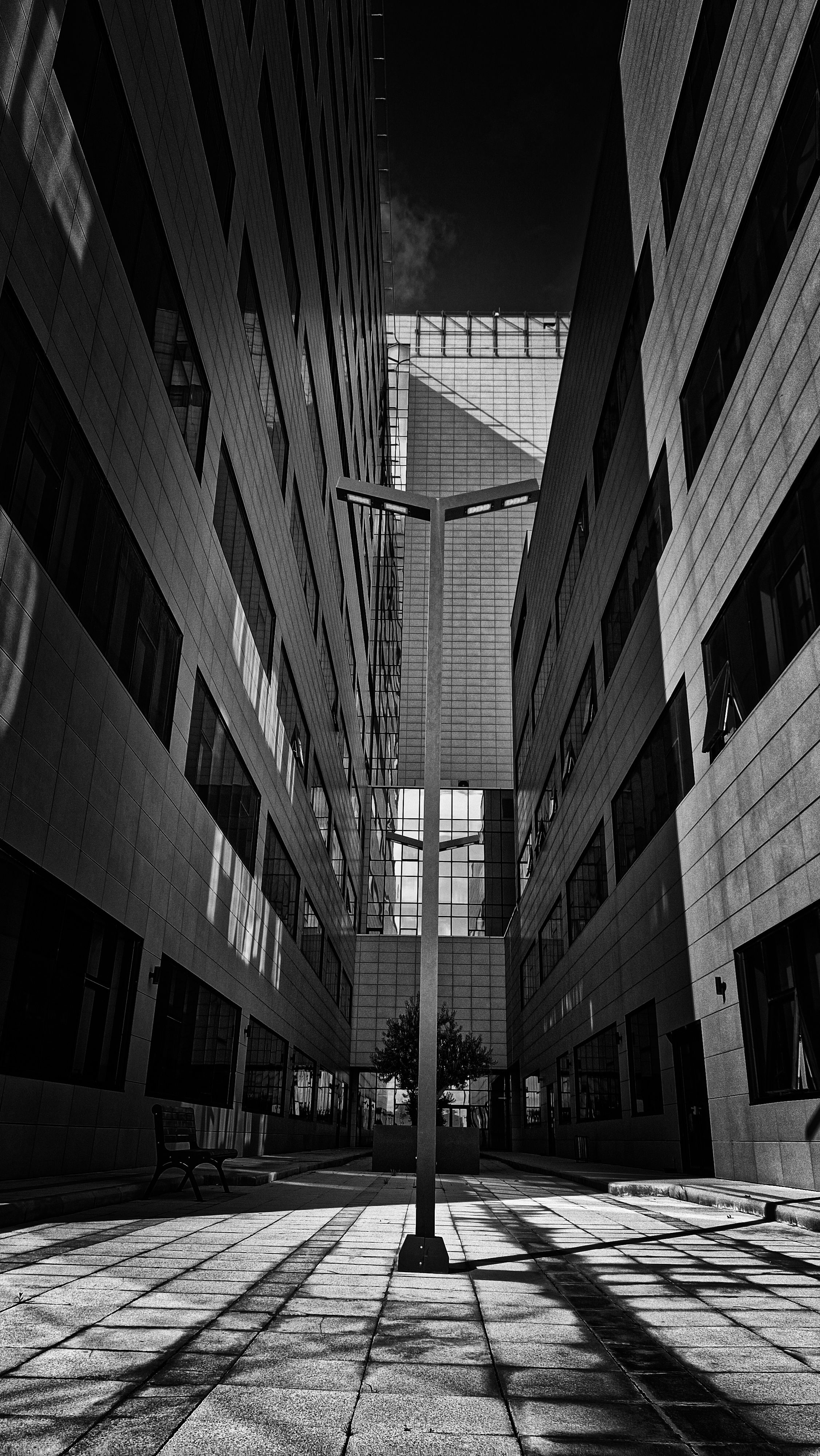 Dramatische zwart-witfoto van moderne stedelijke architectuur met geometrische patronen.