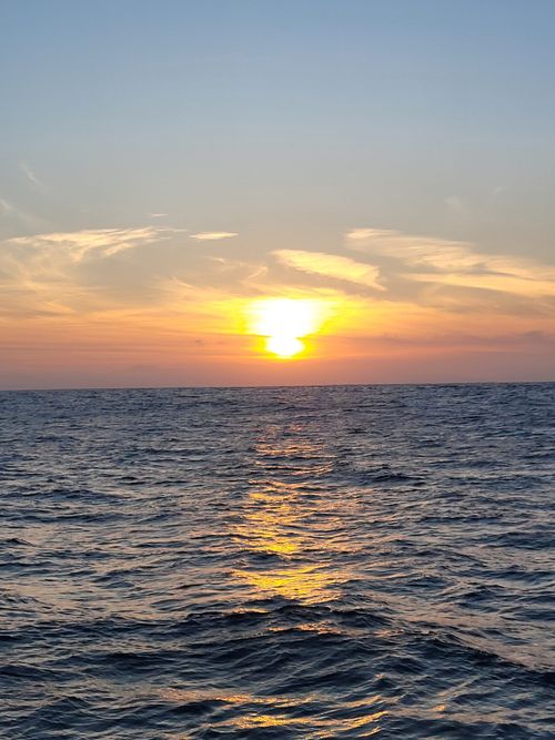Free Breathtaking sunset over the ocean with vibrant skies and tranquil waves. Stock Photo