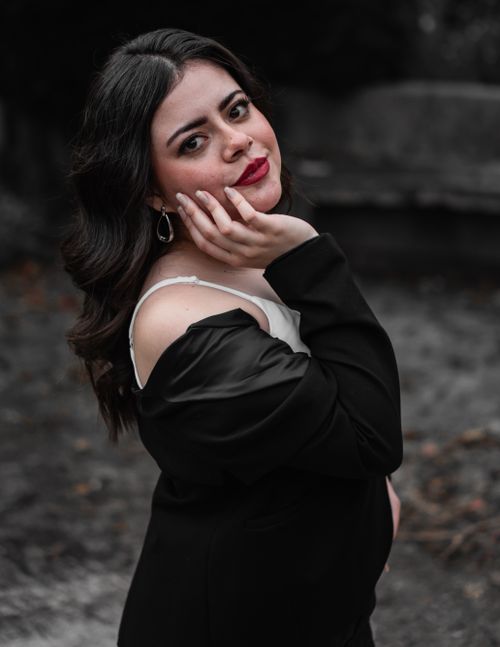Free Charming portrait of a woman outdoors in a classic pose with elegant attire. Stock Photo