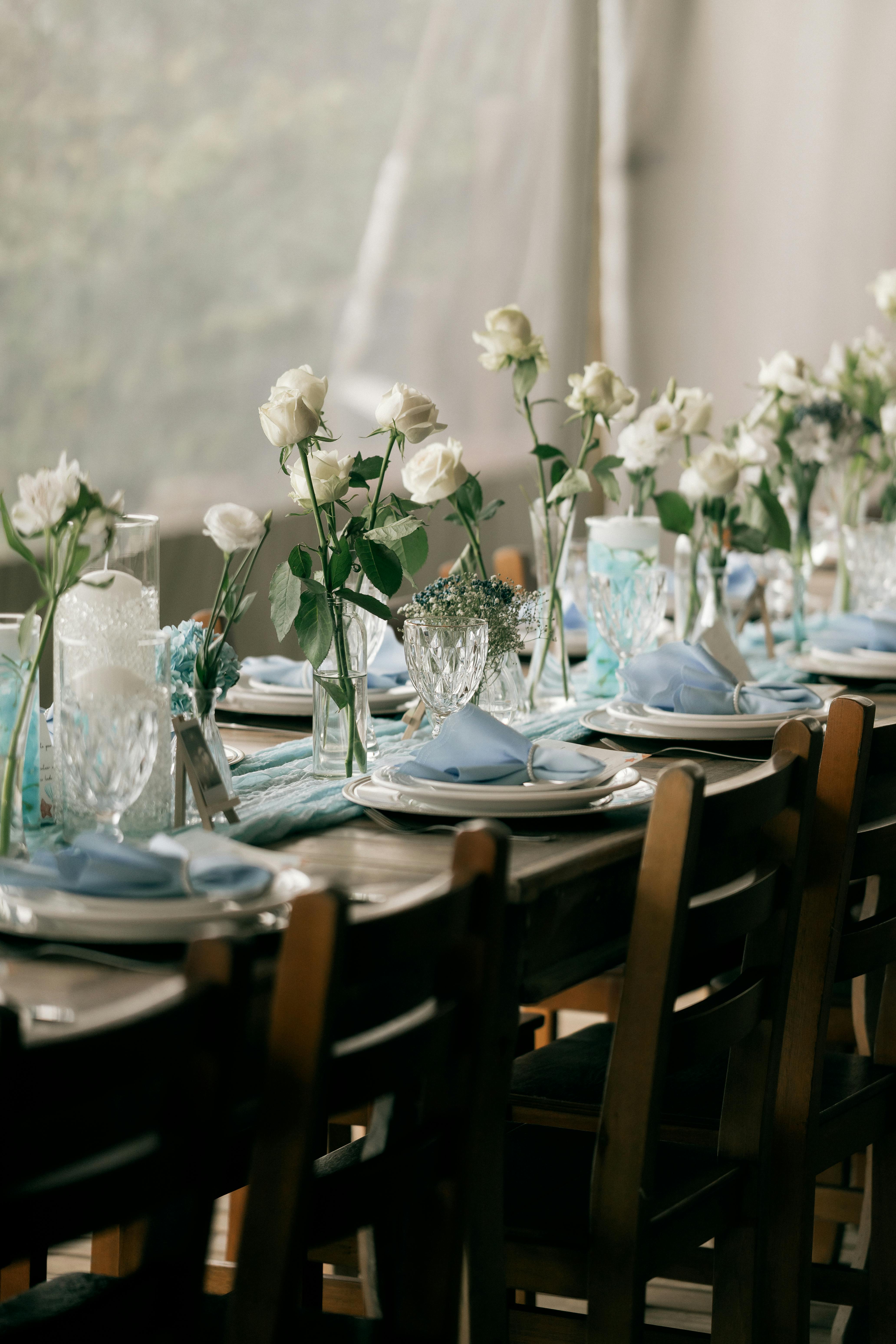Charming table setup with white roses and glassware, perfect for weddings or celebrations.