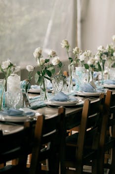 Charming table setup with white roses and glassware, perfect for weddings or celebrations.