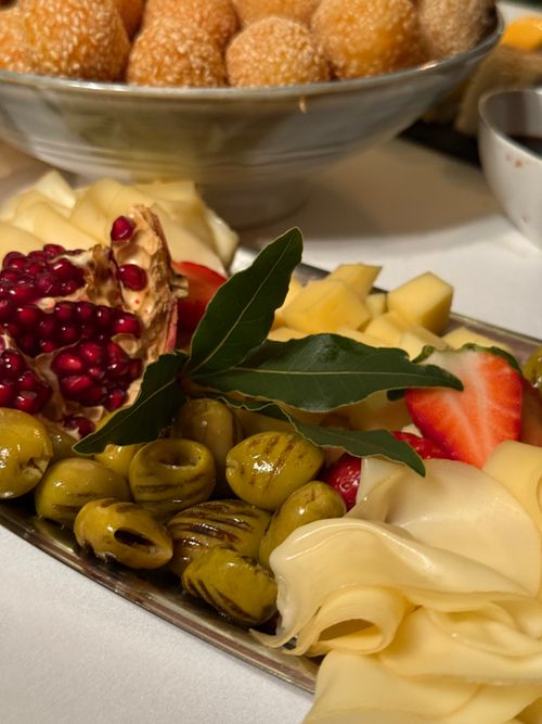 Free A vibrant fruit and cheese platter featuring pomegranate, strawberries, cheese, and green olives. Stock Photo