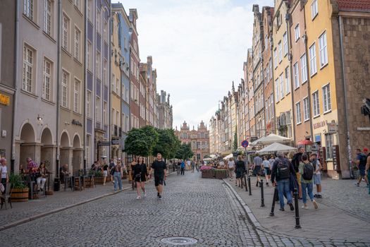Explore the lively streets of Gdańsk, Poland, filled with colorful architecture on a sunny day.