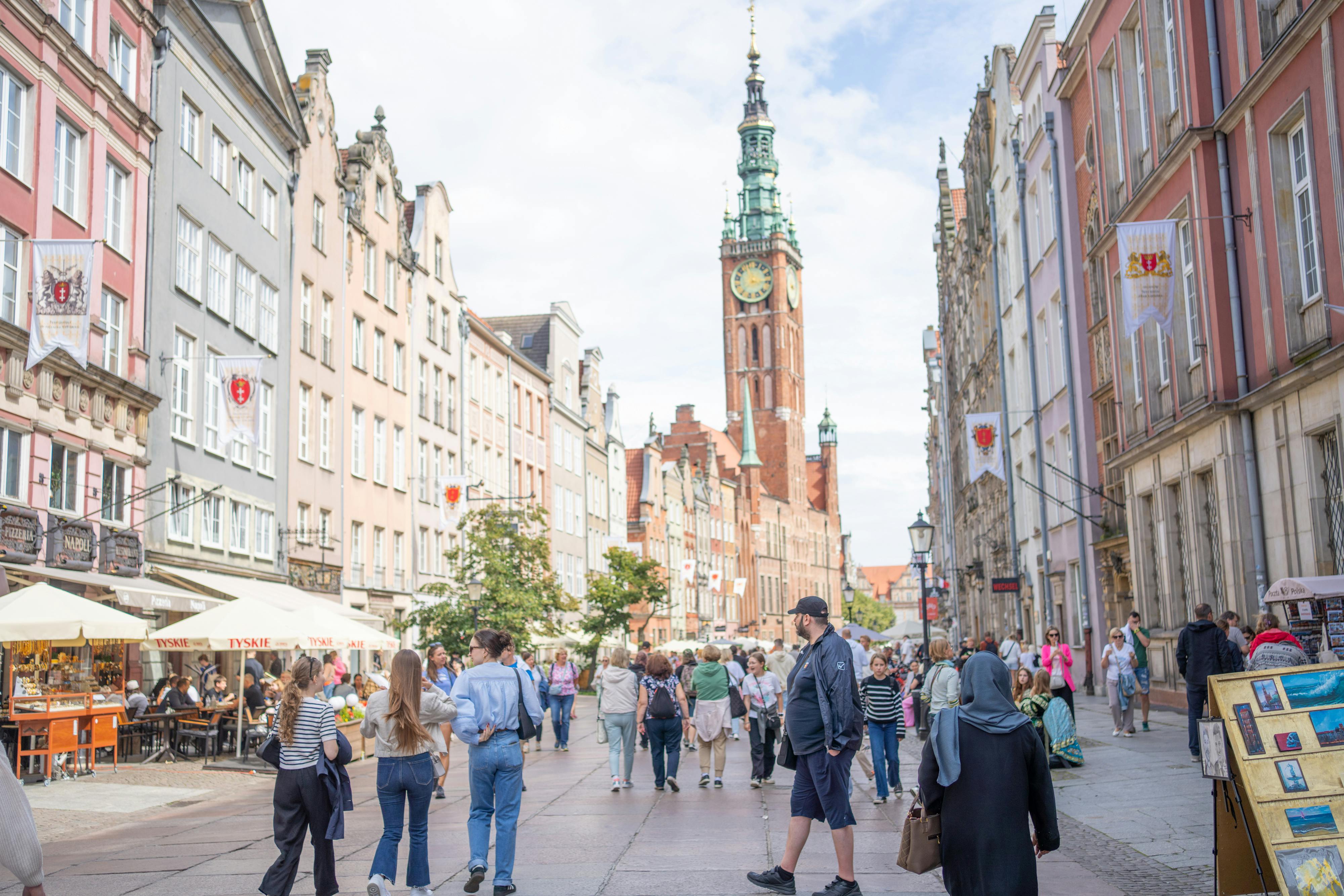 Discover the vibrant atmosphere of Long Street in Gdańsk, Poland, bustling with locals and tourists alike on a sunny day. - Gdansk