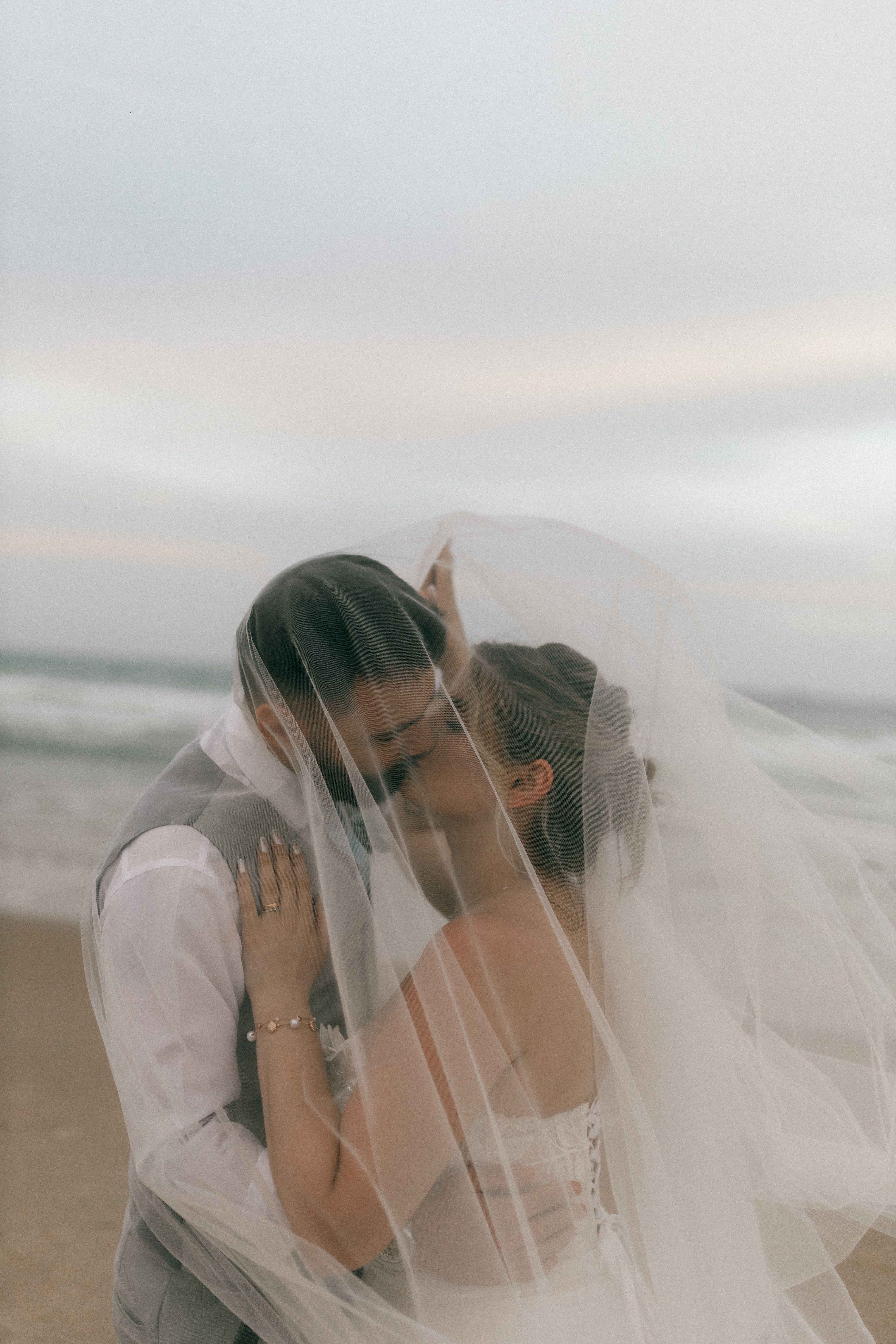 Romantic kiss on a beach beneath a canopy