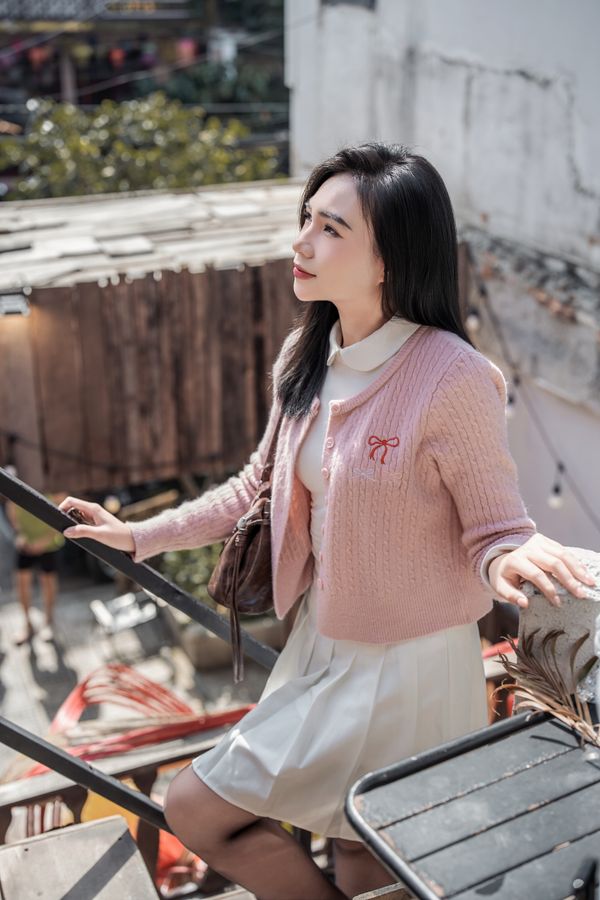 Woman in pink cardigan outdoors