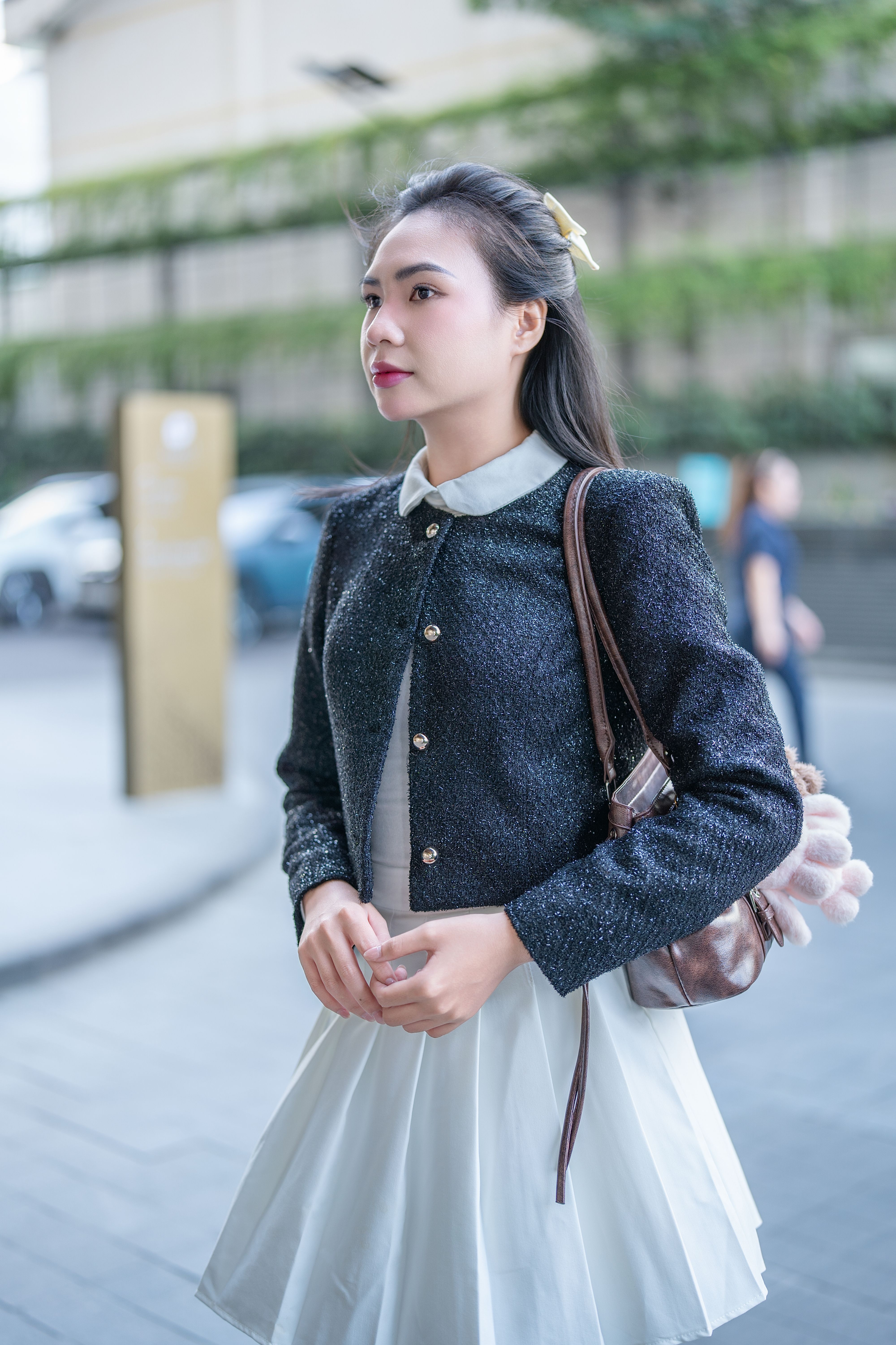 Young woman in chic outfit strolling in a city. Urban fashion and style captured outdoors.