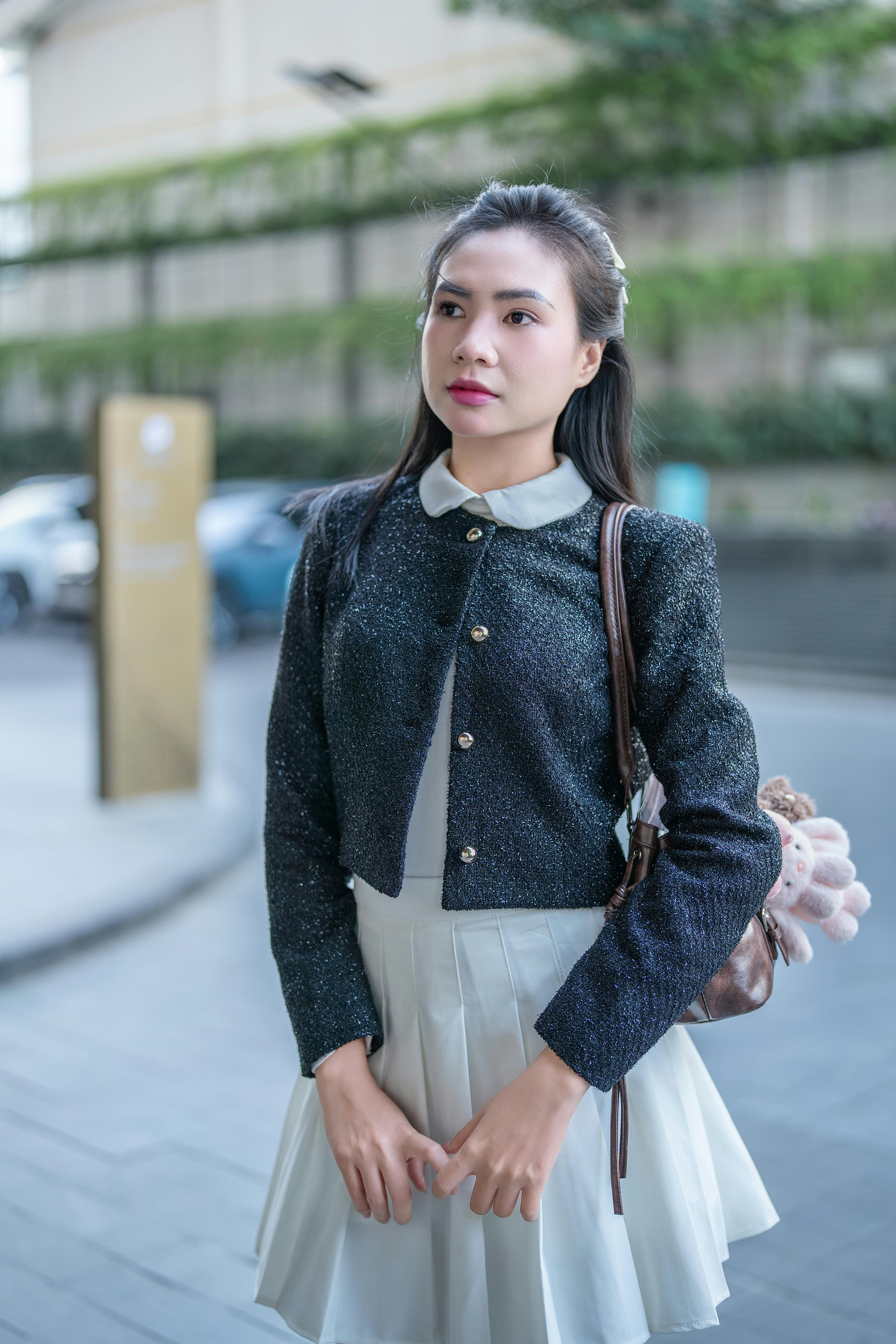 Young woman in chic outfit strolling through a modern city street.