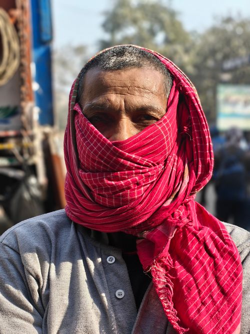 Free Close-up portrait of a mature man outdoors with a red headscarf covering most of his face. Stock Photo