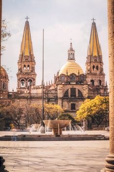 Stunning view of Guadalajara Cathedral with sunny skies and vibrant trees in spring.