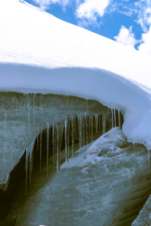 Free A close-up of icicles hanging from a snowy glacier against a bright blue sky in Cuzco, Peru. Stock Photo