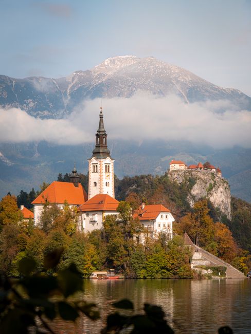 Beautiful landscape of Bled Island Church with stunning mountains and autumn colors, Slovenia.
