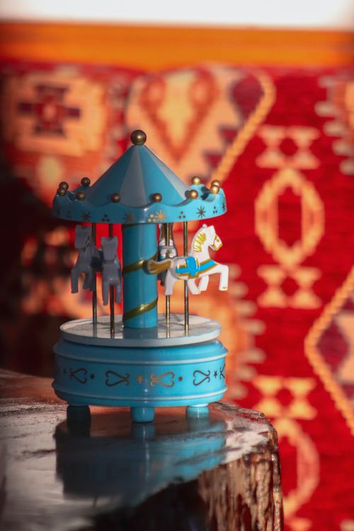 Free Vintage carousel toy captured against a vibrant patterned background, evoking nostalgic childhood charm. Stock Photo
