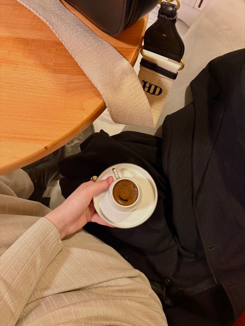 Free A person in a cafe holding an espresso cup, showcasing a casual and stylish moment. Stock Photo