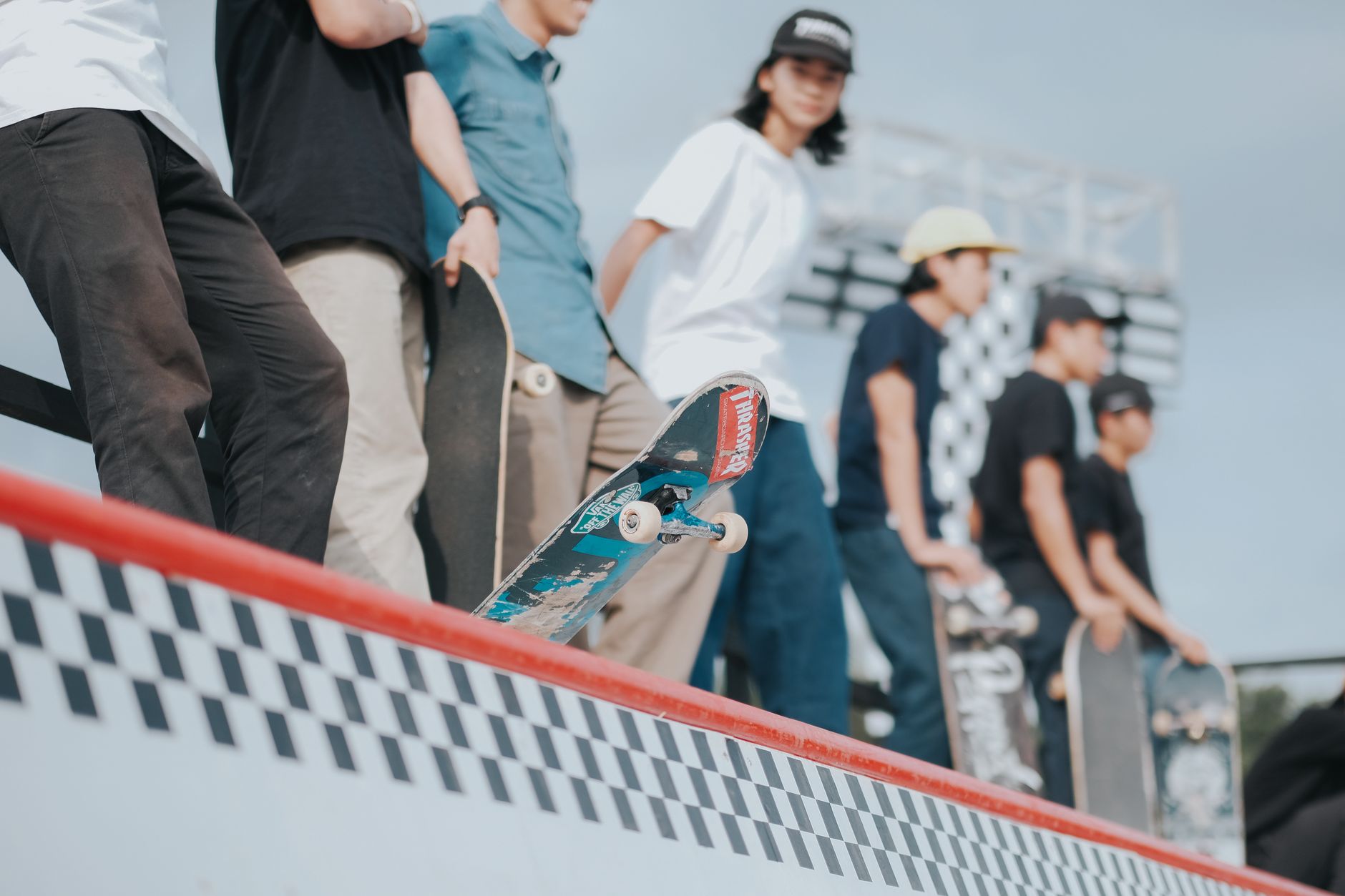 Skater measuring an old Cockfight Skateboards deck inside a Houston garage workshop