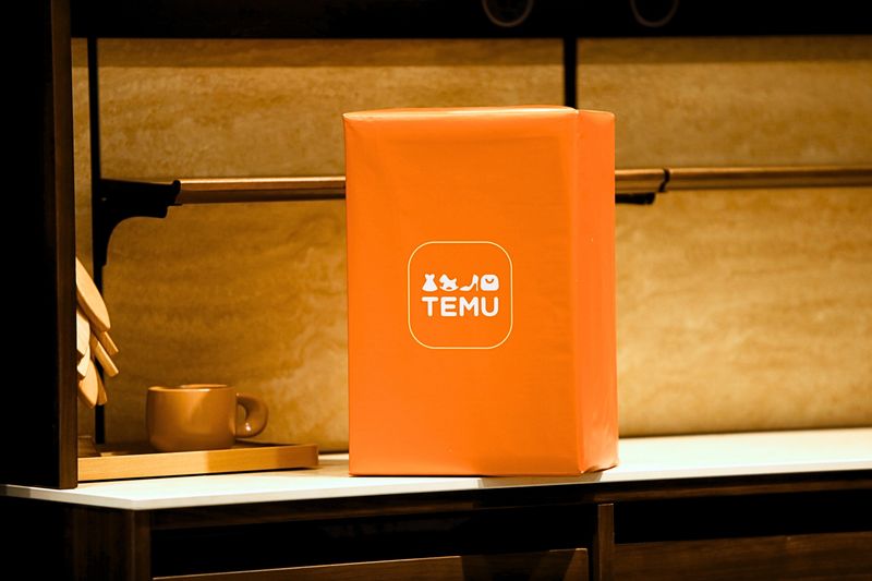 Bright orange parcel box with TEMU logo on a shelf, ideal for ecommerce and shipping concepts.