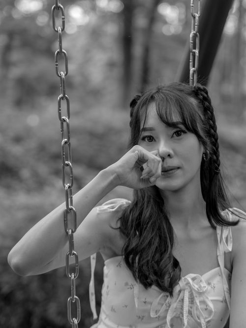 Free Black and white portrait of a woman on a swing in a forest setting, evoking tranquility. Stock Photo