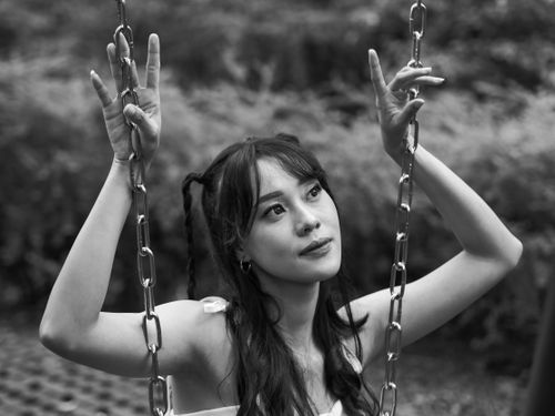 Free Artistic black and white photo of a young woman on a swing, conveying introspection. Stock Photo