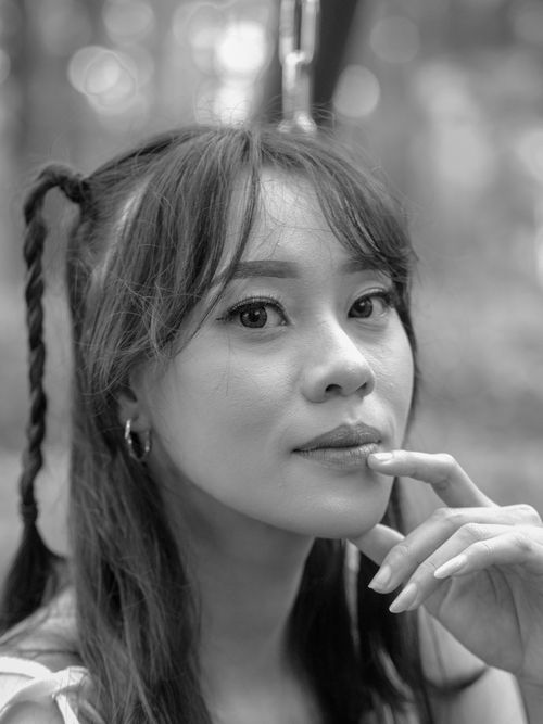 Free Close-up black and white portrait of a woman outdoors with a pensive expression. Stock Photo