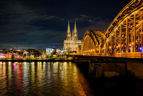 Free A breathtaking night view of Cologne Cathedral and Hohenzollern Bridge over the Rhine River in Germany. Stock Photo