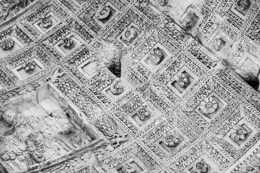 Detailed view of ancient architectural stone carvings featuring geometric and floral patterns.