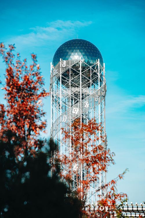 Free Iconic Alphabetic Tower set against a blue sky, framed by red autumn leaves, in Batumi, Georgia. Stock Photo