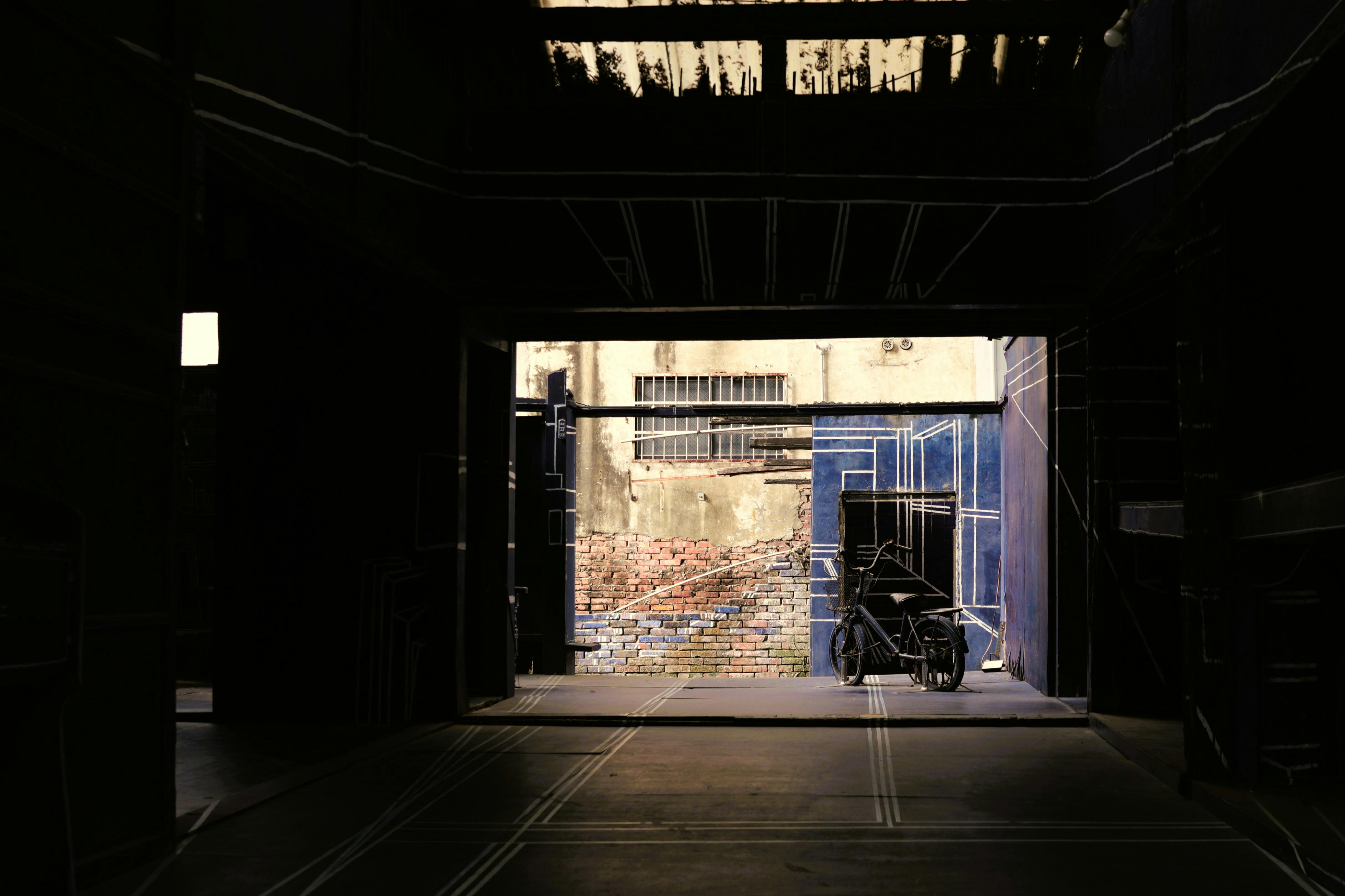 Gratis Un callejón urbano poco iluminado con paredes rústicas y un carro solitario en Taiwán. Foto de stock