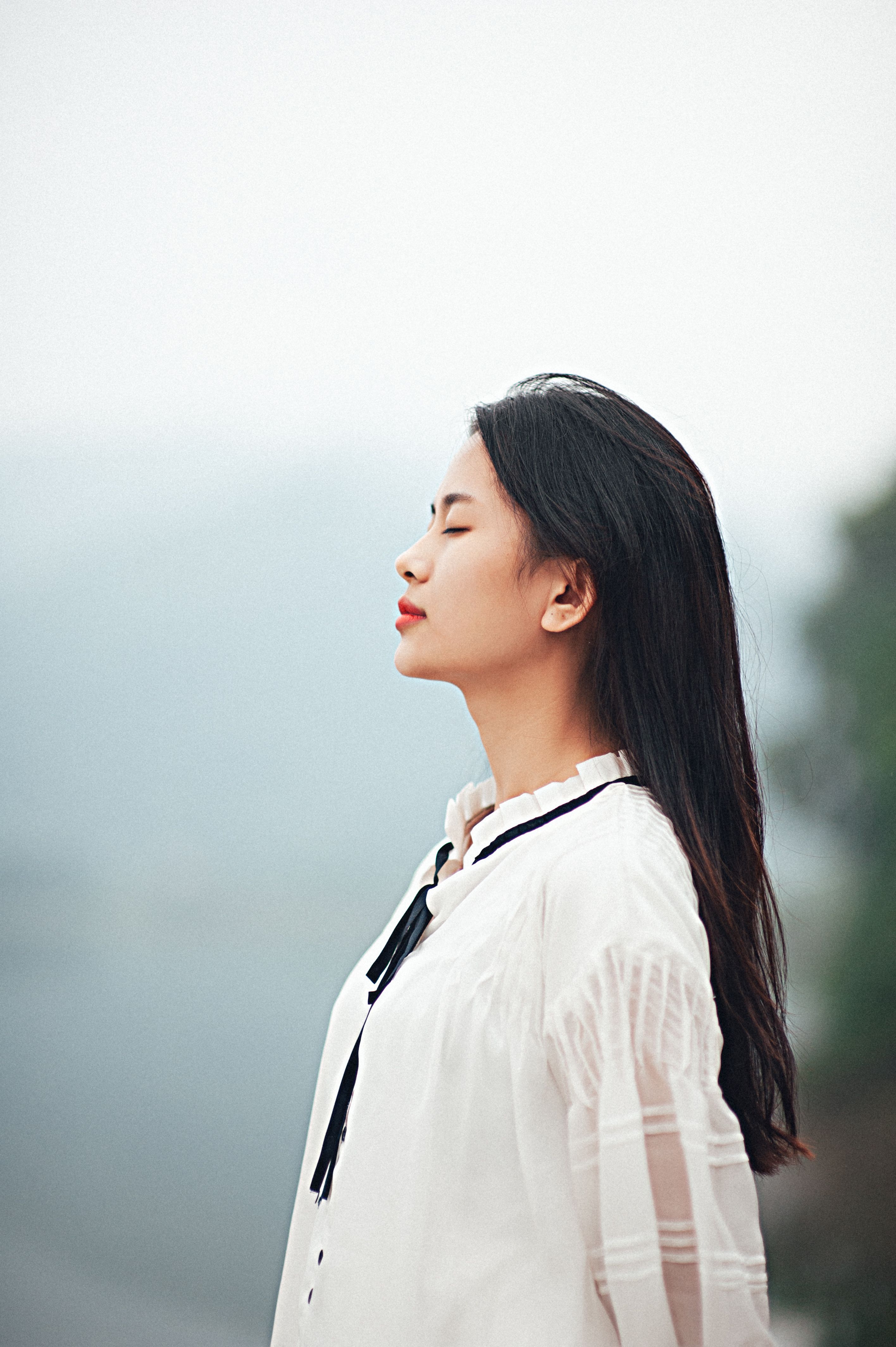 Peaceful outdoor portrait of a woman enjoying tranquility.