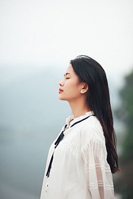 Peaceful outdoor portrait of a woman enjoying tranquility.