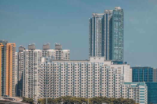 High-rise residential buildings in Hong Kong's skyline with a clear blue sky backdrop.
